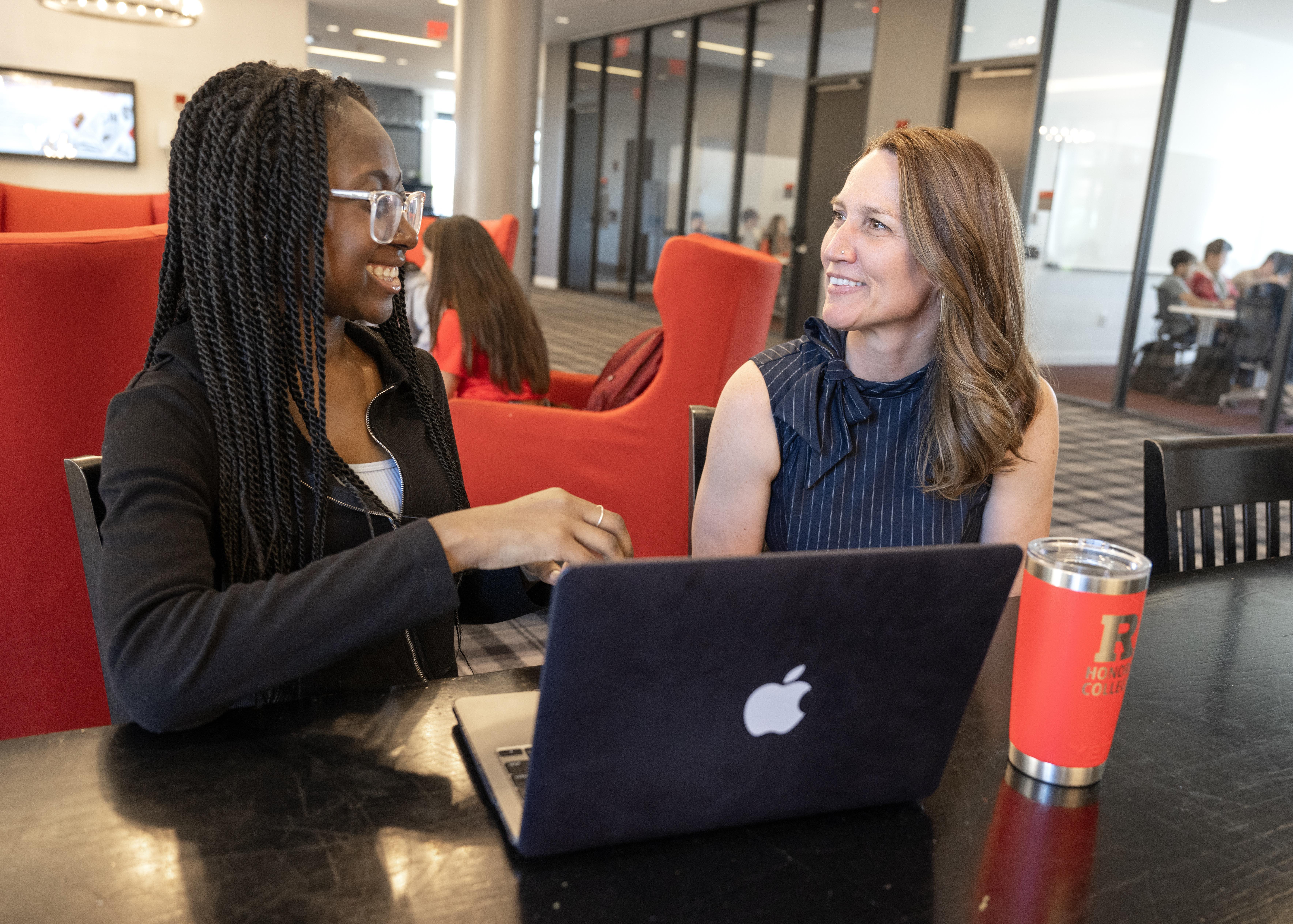 Original Caption:  Izabellar Tulasi (SAS '27) shows work on laptop to Kristen Syrett, professor Linguistics, and Center for Cognitive Science in the lounge of Honors College